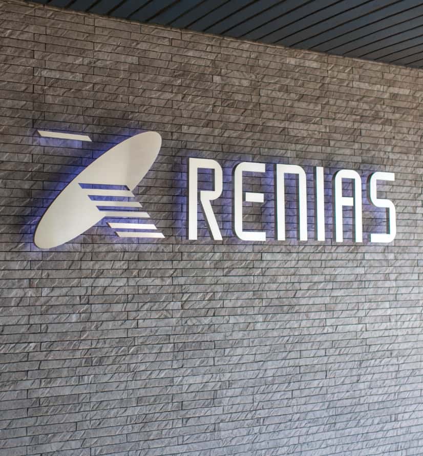株式会社レニアスのロゴマークのモニュメントが設置された壁の写真