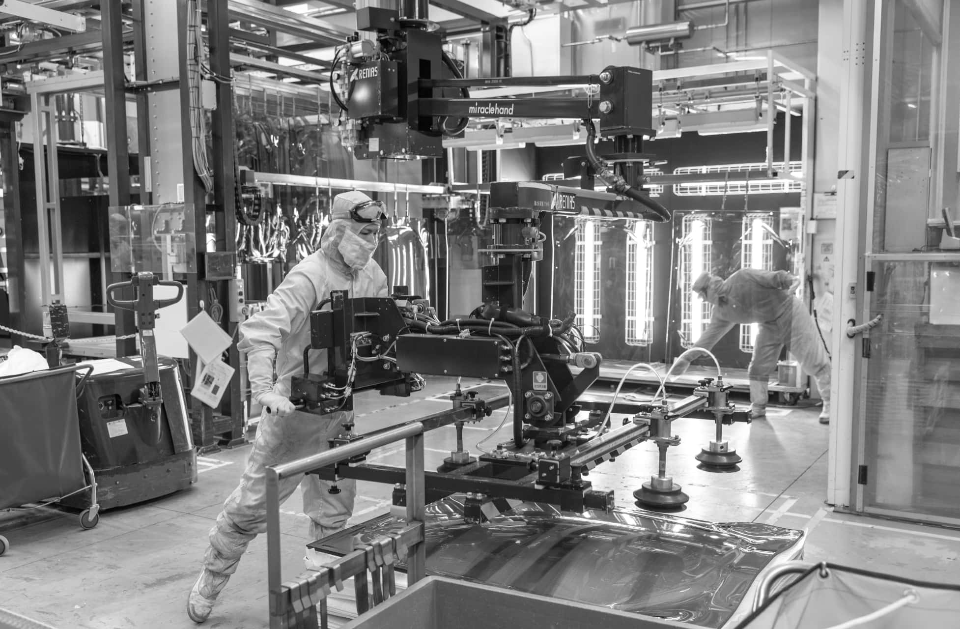 白い作業着を着た2人のスタッフが工場で作業をしている写真