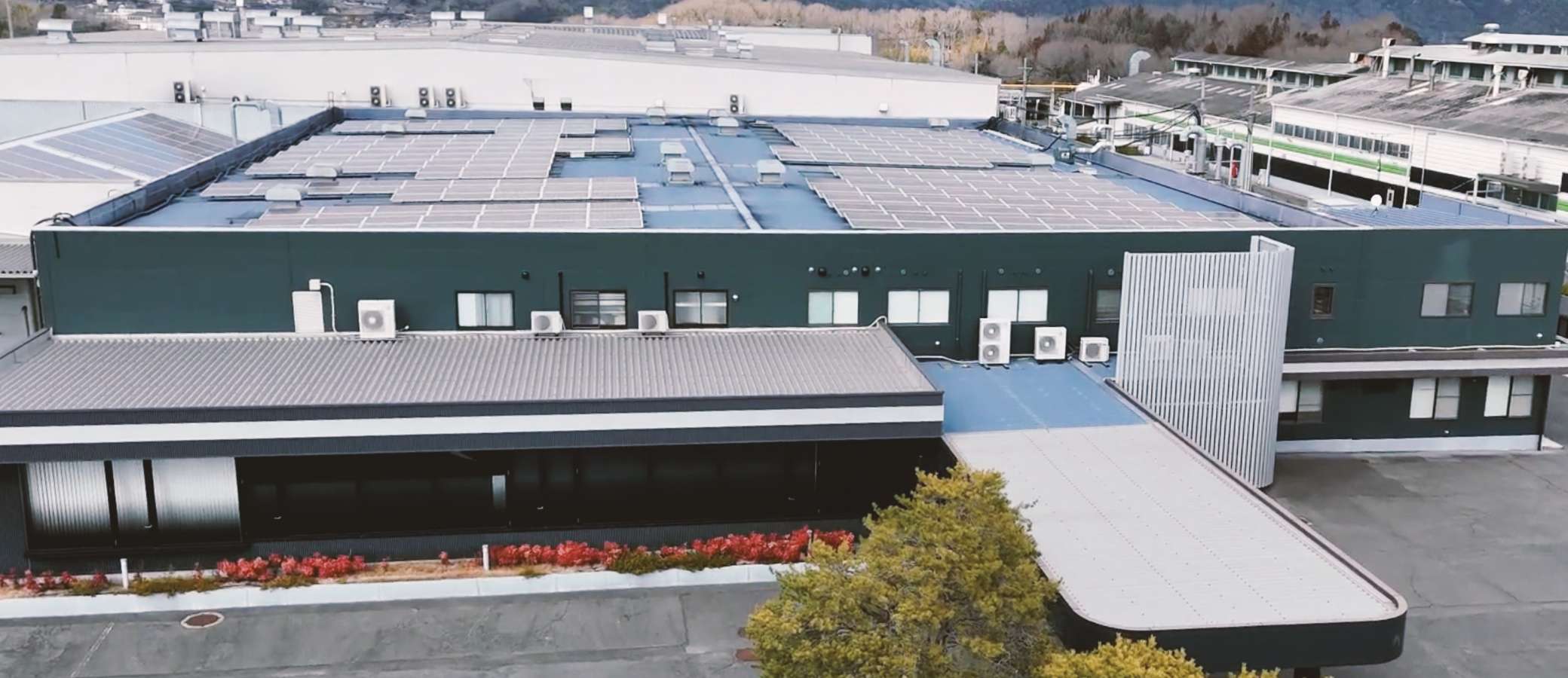 工場の屋根の上に設置されているソーラーパネルを斜め上から見た写真