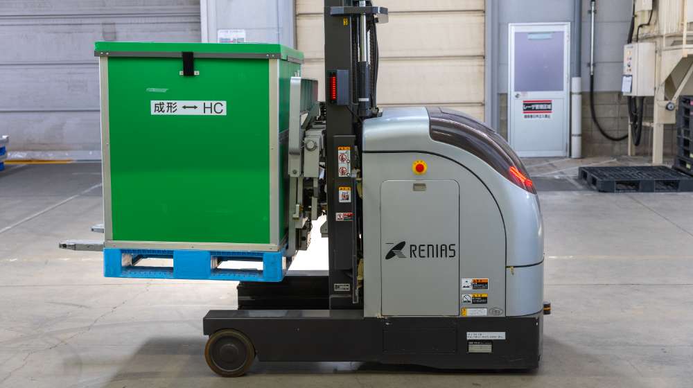 工場内を走る、荷物を運ぶ機械の写真