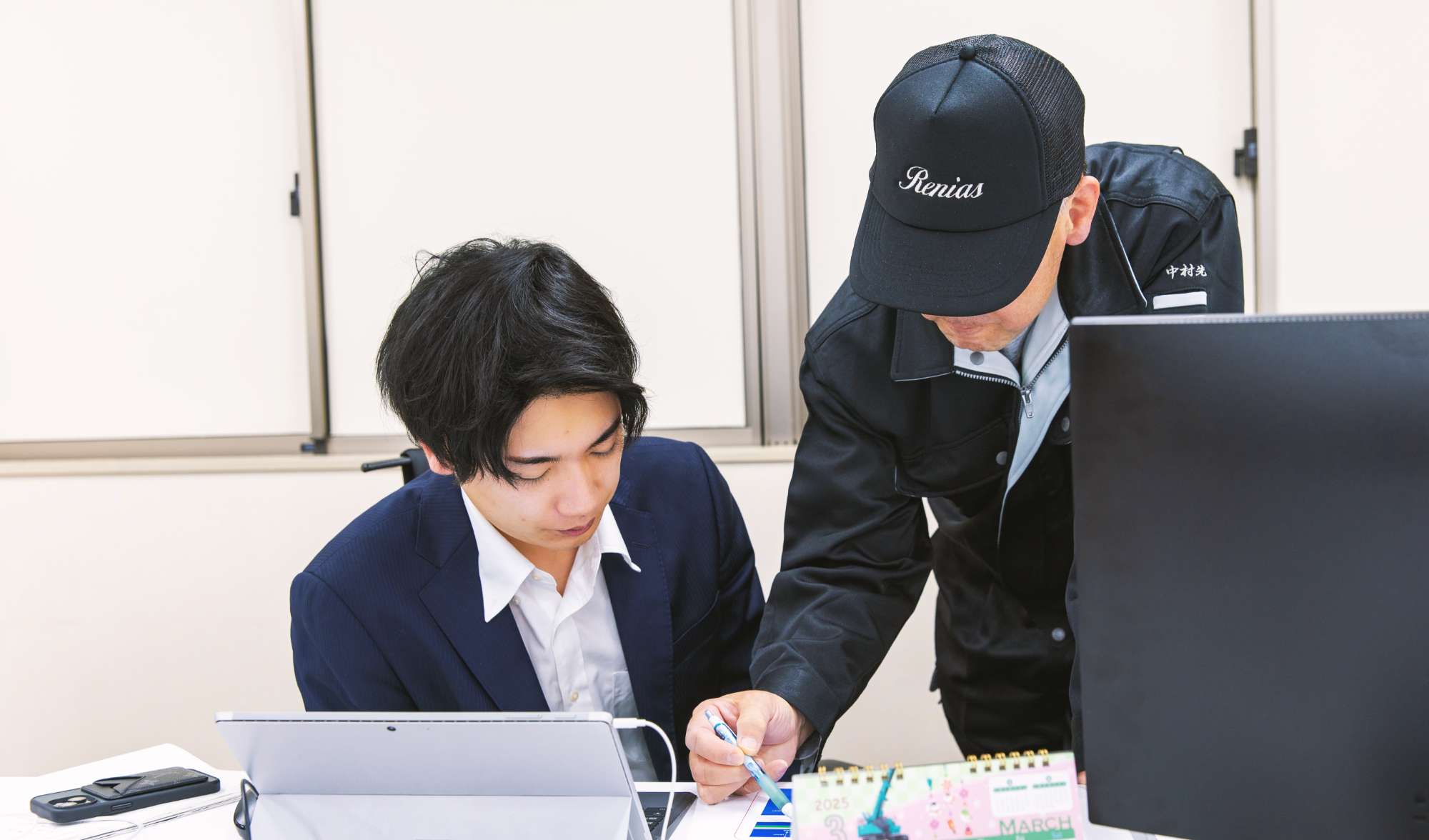 先輩スタッフに指導をしてもらっている田中さんの写真