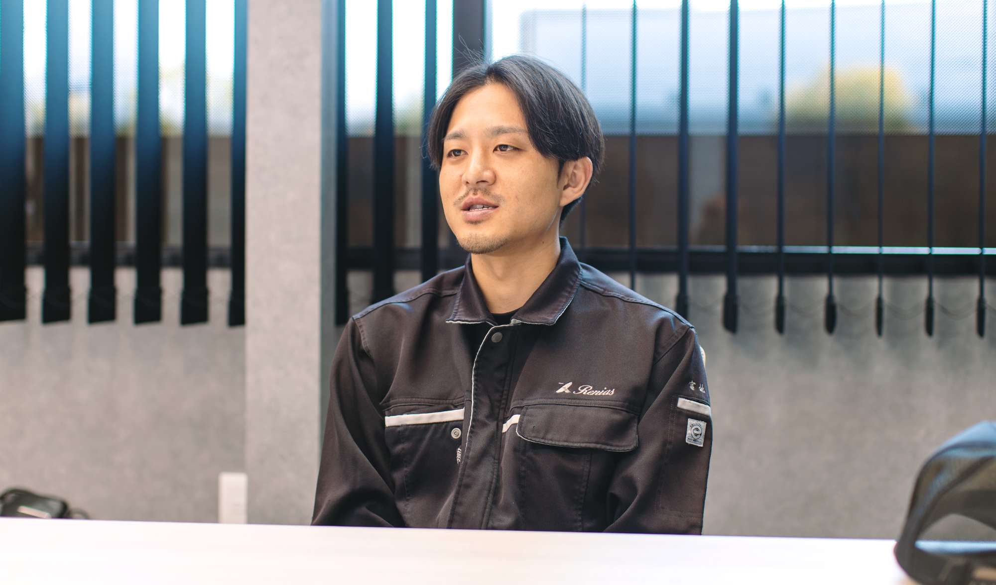 椅子に座って話す宮地さんの写真